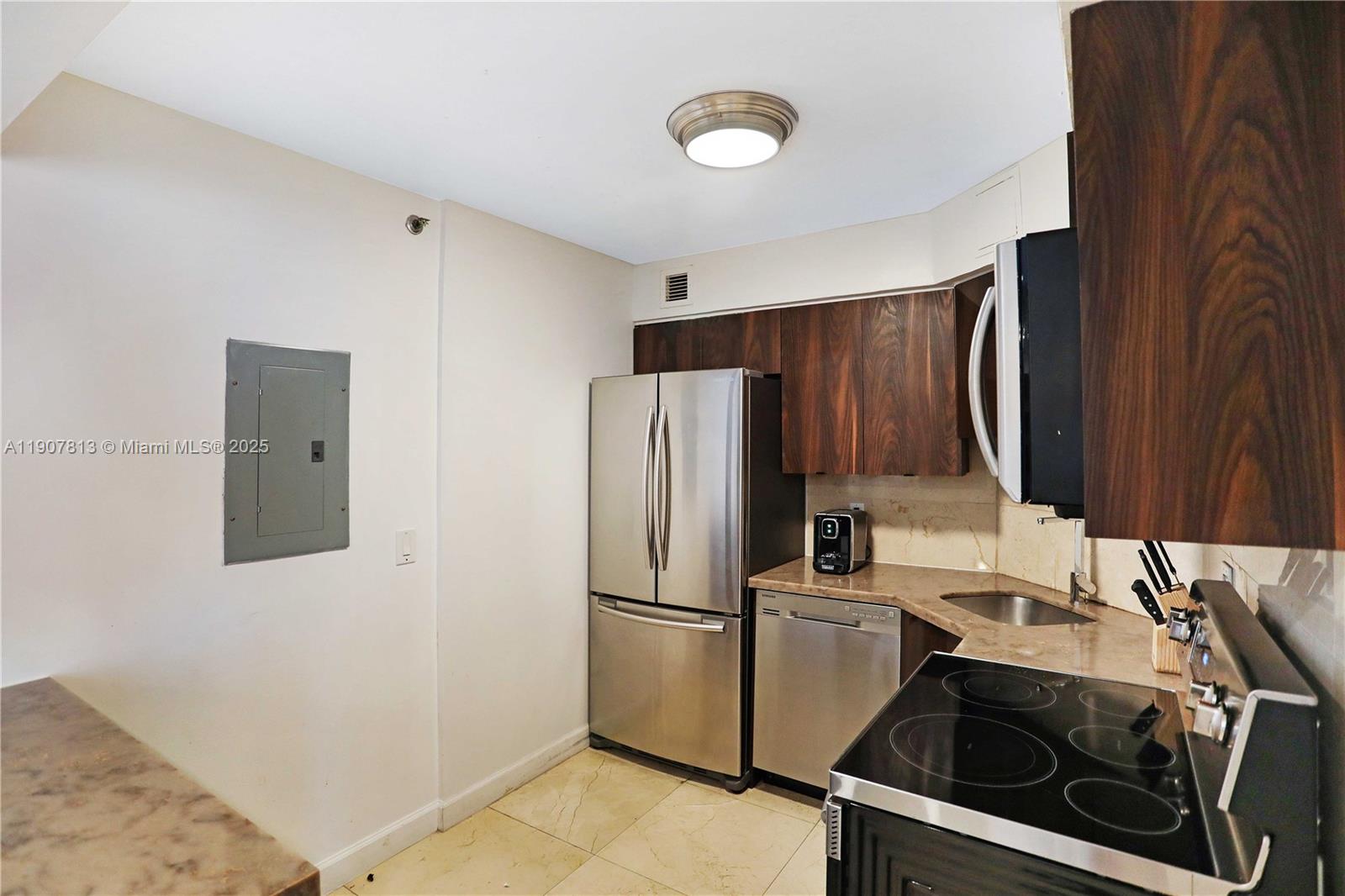 5225 Collins Avenue, Unit 1216 Miami Beach, FL 33140 - Photo 13 of 49 a kitchen with a sink cabinets and stainless steel appliances