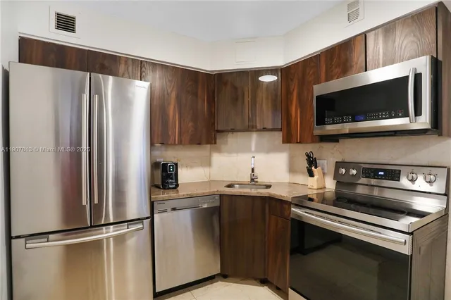 a kitchen with stainless steel appliances a sink a stove a microwave and cabinets