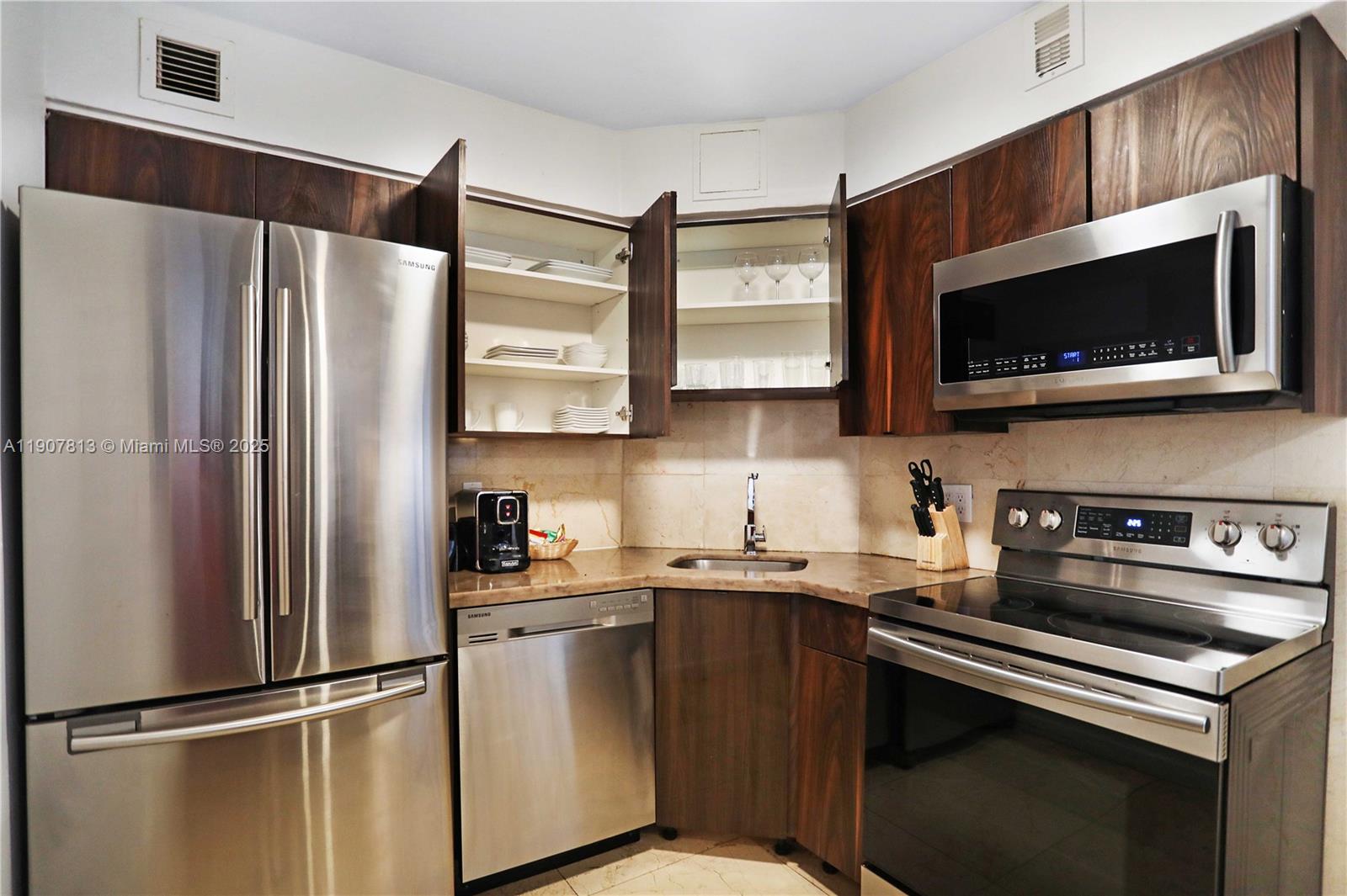5225 Collins Avenue, Unit 1216 Miami Beach, FL 33140 - Photo 15 of 49 a kitchen with stainless steel appliances a refrigerator stove and microwave