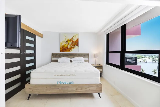 a bedroom with a bed and painting on the wall