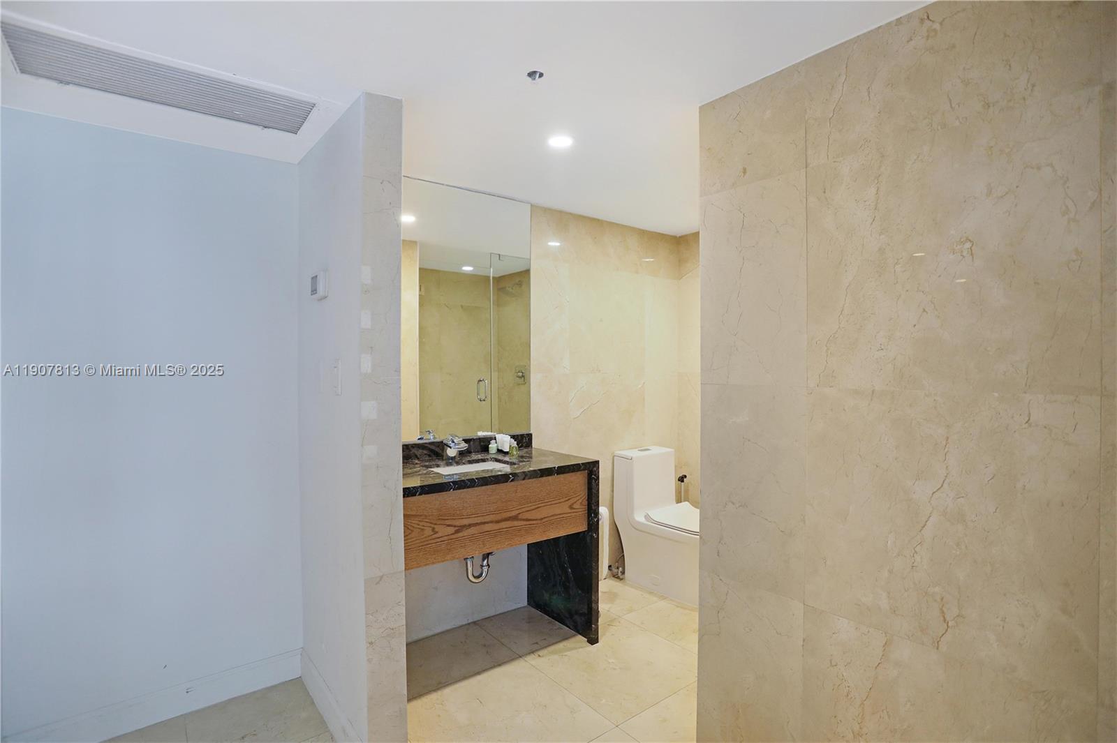 5225 Collins Avenue, Unit 1216 Miami Beach, FL 33140 - Photo 19 of 49 a bathroom with a double vanity sink and mirror