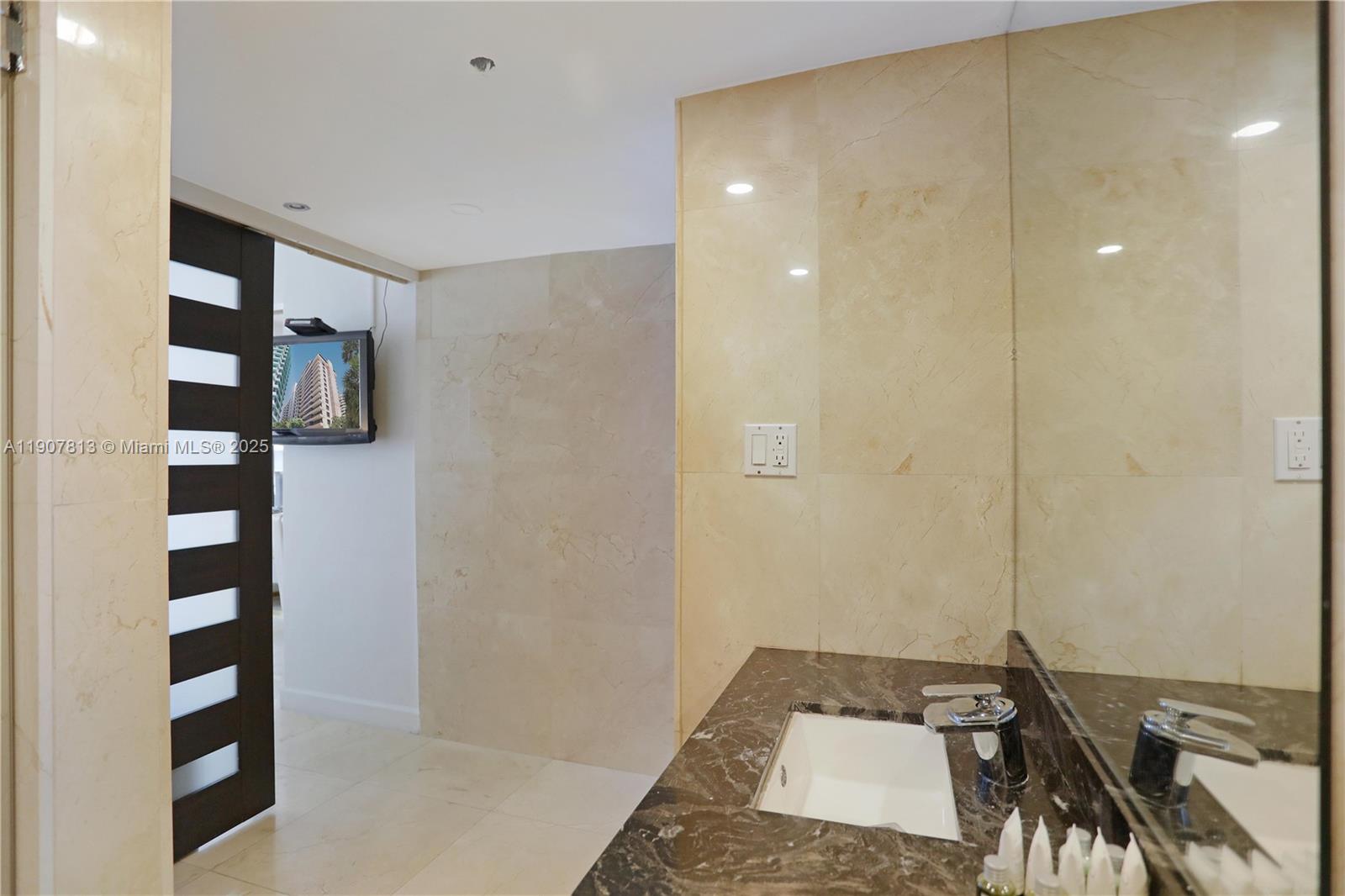 5225 Collins Avenue, Unit 1216 Miami Beach, FL 33140 - Photo 23 of 49 a bathroom with a sink and a shower