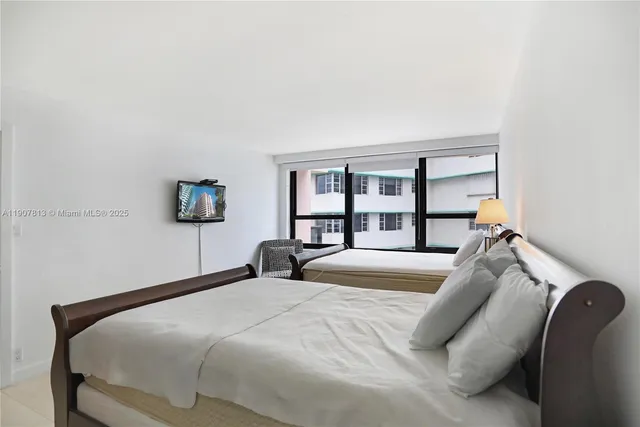 a bedroom with a bed and a large mirror