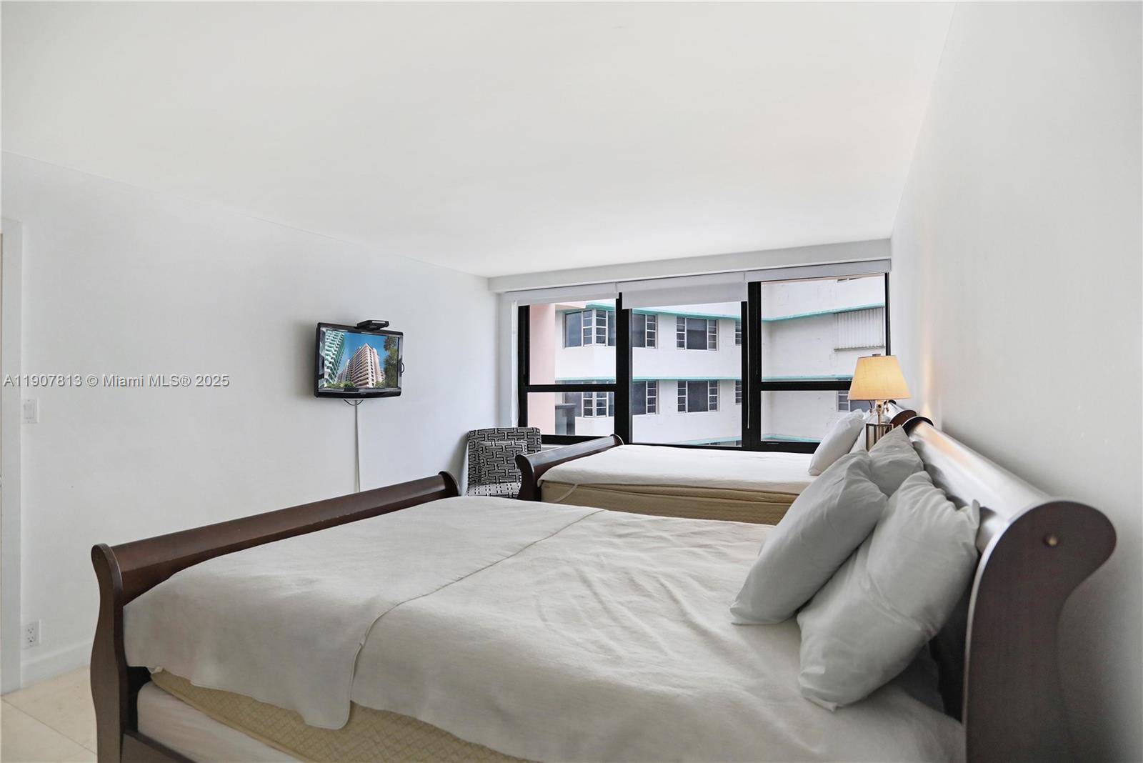 5225 Collins Avenue, Unit 1216 Miami Beach, FL 33140 - Photo 26 of 49 a bedroom with a bed and a large mirror