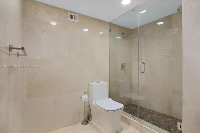 a bathroom with a toilet and a shower