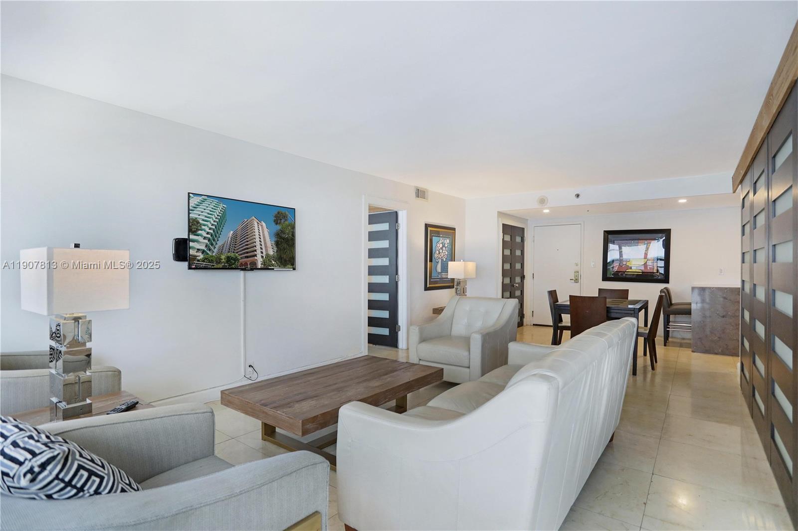 5225 Collins Avenue, Unit 1216 Miami Beach, FL 33140 - Photo 6 of 49 a living room with furniture and a flat screen tv
