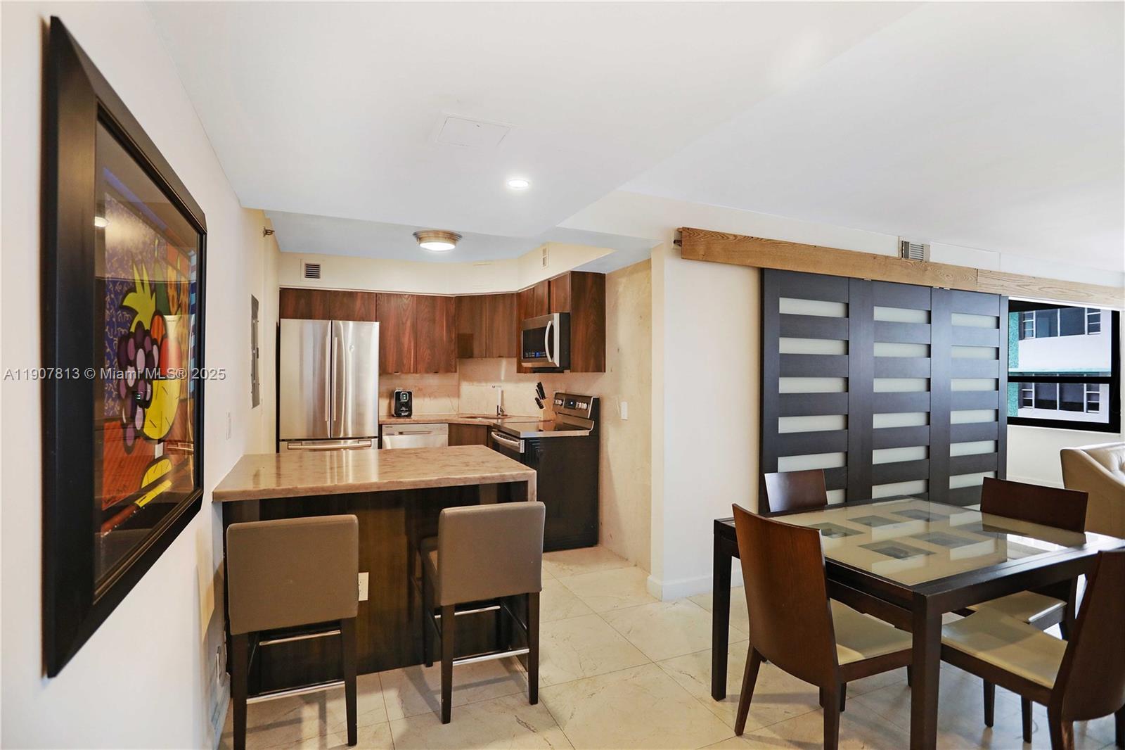 5225 Collins Avenue, Unit 1216 Miami Beach, FL 33140 - Photo 8 of 49 a view of a dining room with furniture and a book shelf