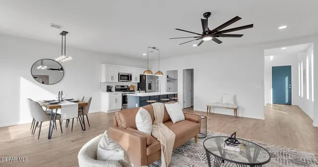 a living room with furniture kitchen and a chandelier