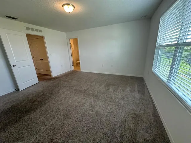 a bathroom with a granite countertop sink a mirror a toilet and shower