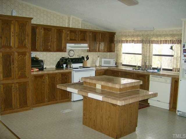449 Wintergreen Road Timberlake, NC 27583 - Photo 2 of 12 a kitchen with a stove a sink a refrigerator and cabinets