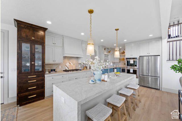 1447 North 1350 E Street, Unit 5 Mapleton, UT 84664 - Photo 2 of 10 Kitchen with appliances with stainless steel finishes, pendant lighting, a kitchen breakfast bar, light wood-style floors, and recessed lighting