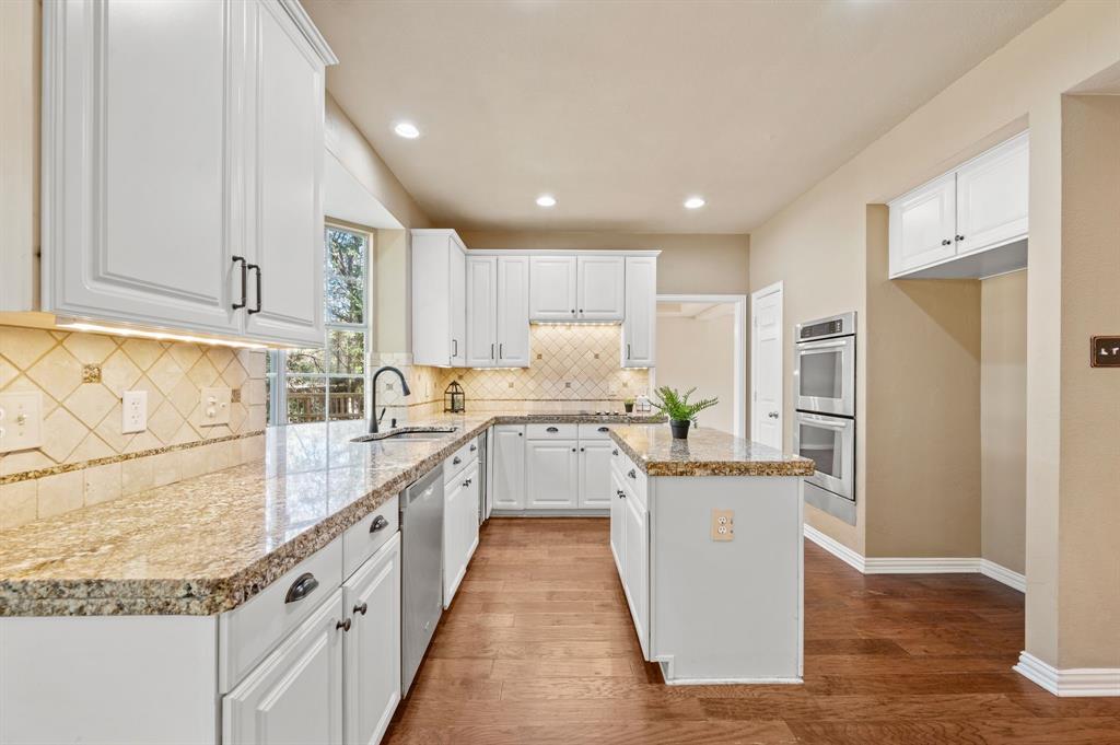 2504 Springhill Drive Grapevine, TX 76051 - Photo 10 of 32 Kitchen with white cabinets, a center island, dark wood finished floors, light stone counters, and recessed lighting