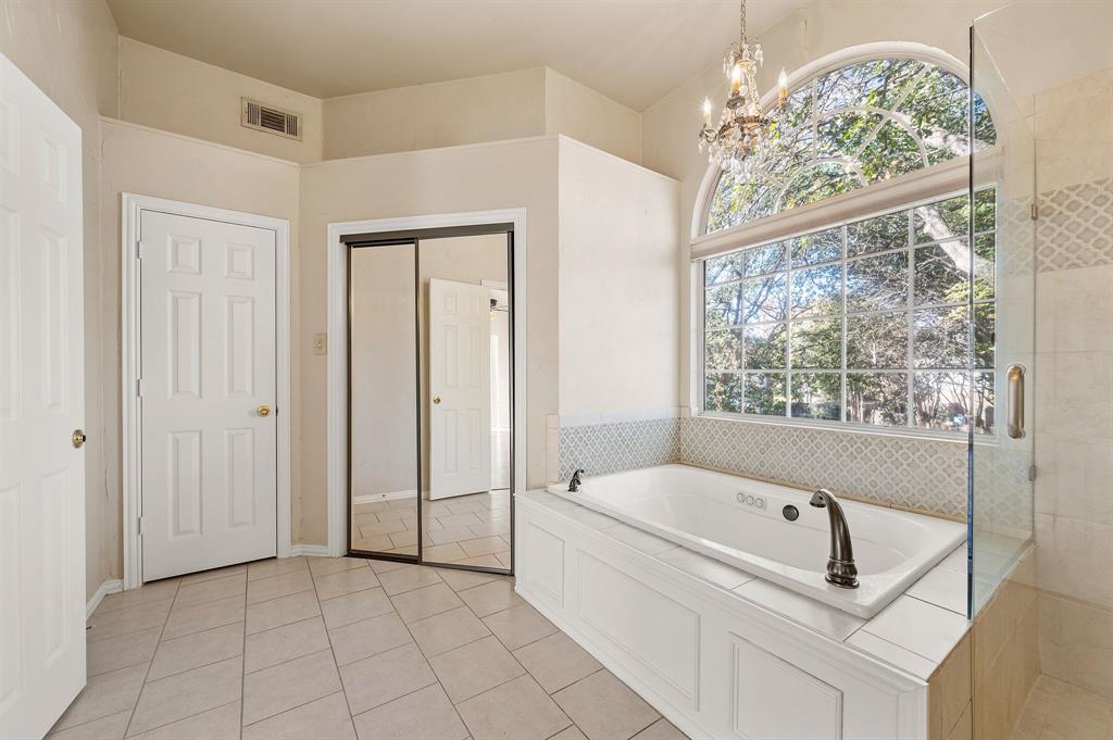 2504 Springhill Drive Grapevine, TX 76051 - Photo 20 of 32 Bathroom with a garden tub, a chandelier, light tile patterned floors, and a shower stall