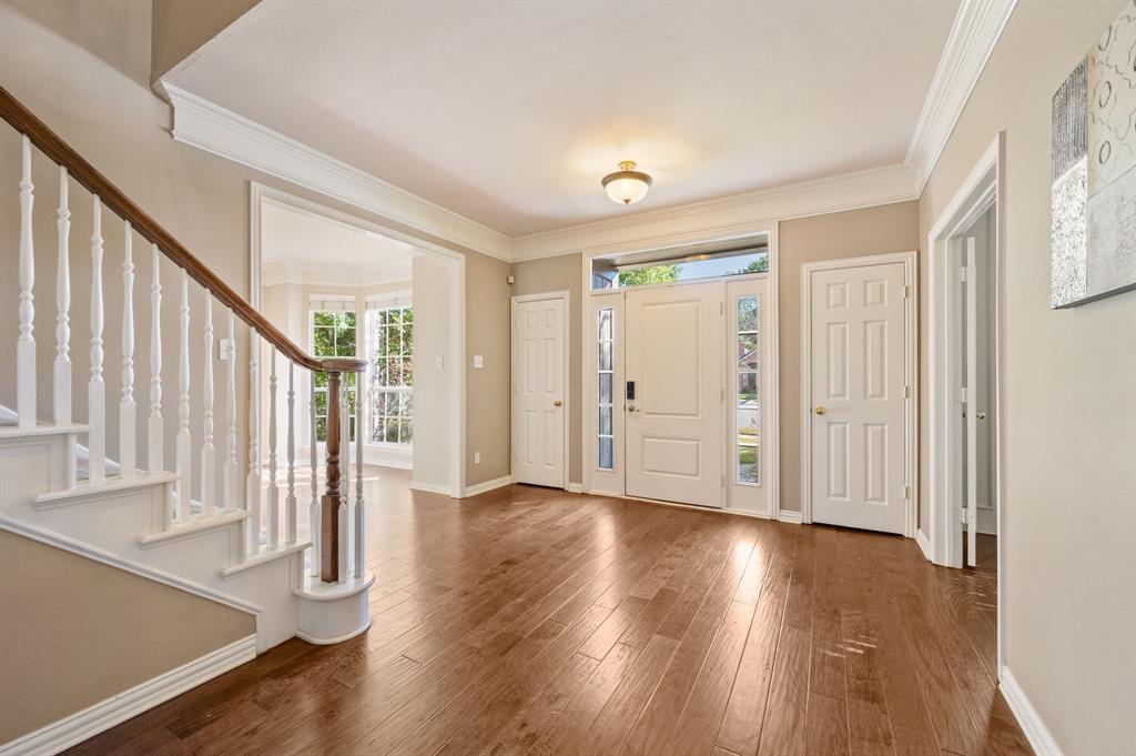 2504 Springhill Drive Grapevine, TX 76051 - Photo 5 of 32 Foyer with healthy amount of natural light, ornamental molding, stairway, and wood-type flooring