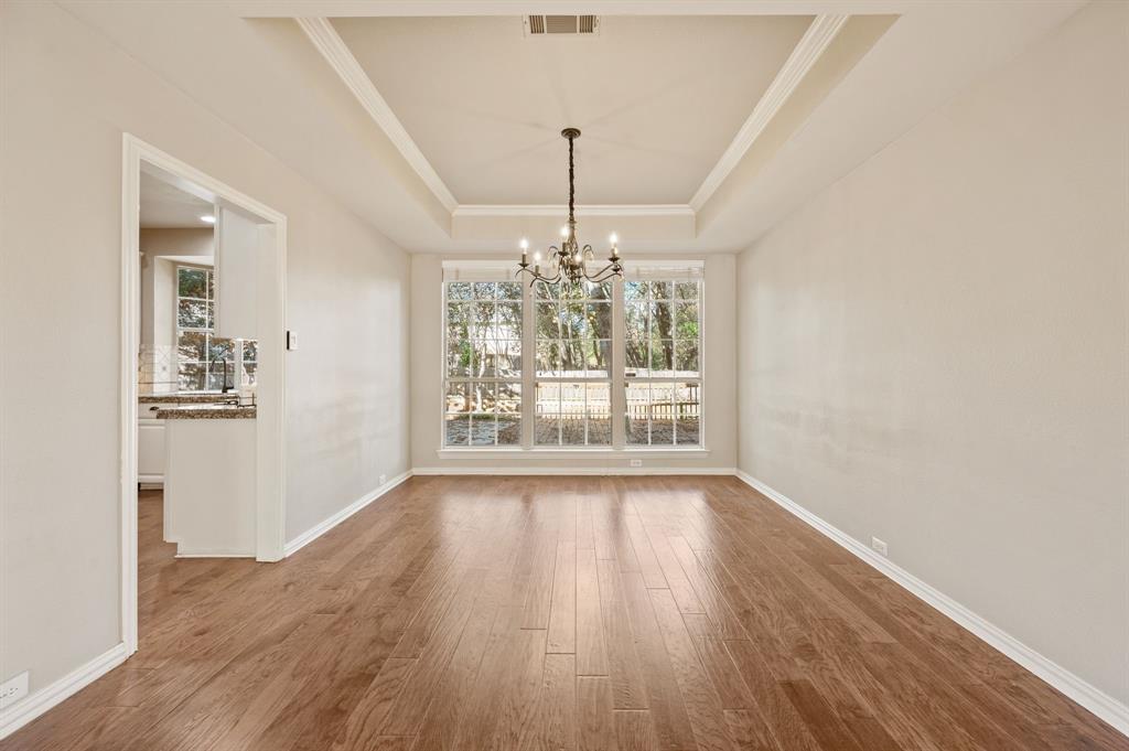 2504 Springhill Drive Grapevine, TX 76051 - Photo 8 of 32 Dining area with a raised ceiling, wood finished floors, a chandelier, and crown molding