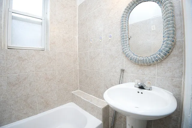 a bathroom with a sink and bathtub with toilet