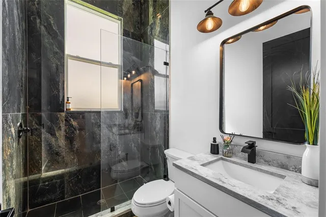 a bathroom with a toilet a sink and mirror