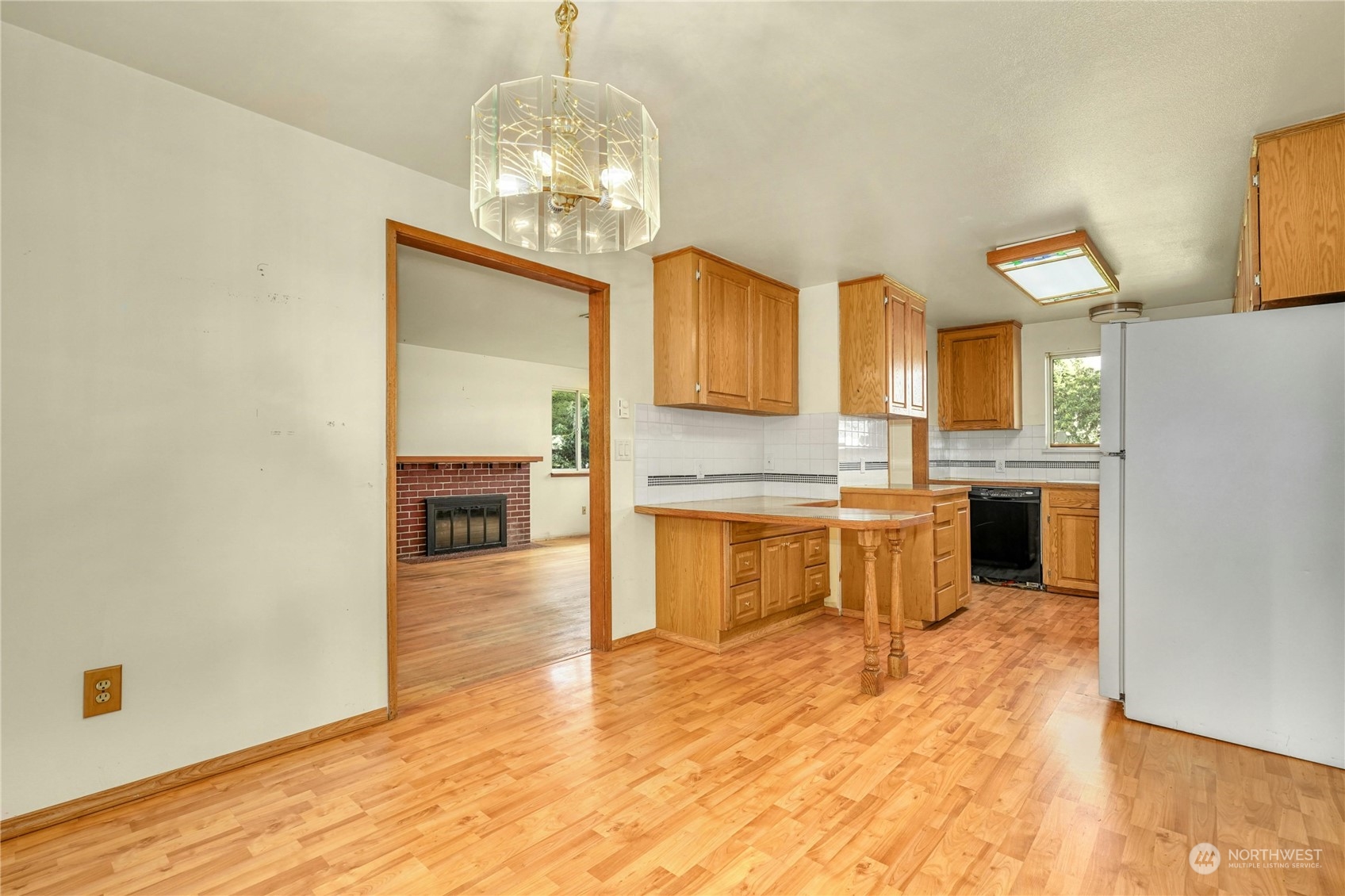 17316 North Road Bothell, WA 98012 - Photo 12 of 32 a large kitchen with a chandelier stainless steel appliances and cabinets