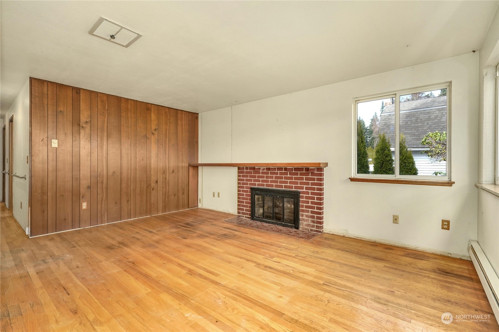 17316 North Road Bothell, WA 98012 - Photo 6 of 32 a view of an empty room with a fireplace and a window