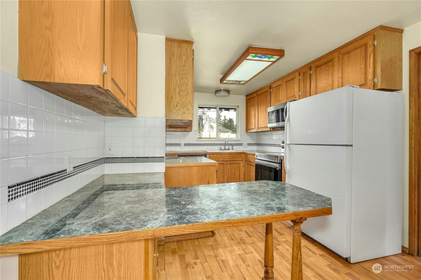 17316 North Road Bothell, WA 98012 - Photo 10 of 32 a kitchen with stainless steel appliances granite countertop a sink and a refrigerator