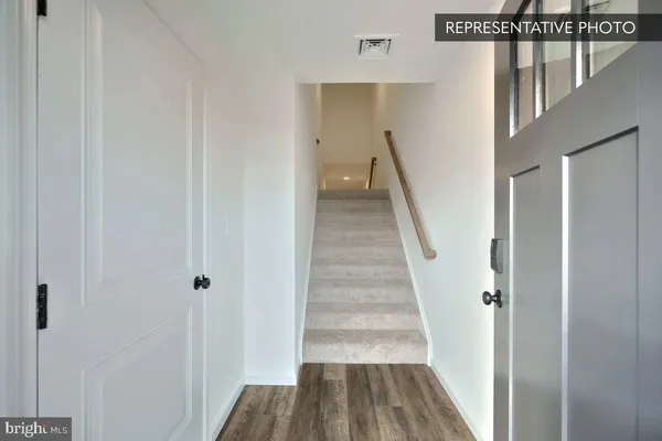 a view of a hallway with wooden floor and entryway