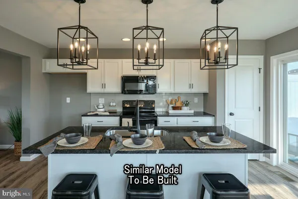 a kitchen with stainless steel appliances granite countertop a sink a stove and a wooden floor