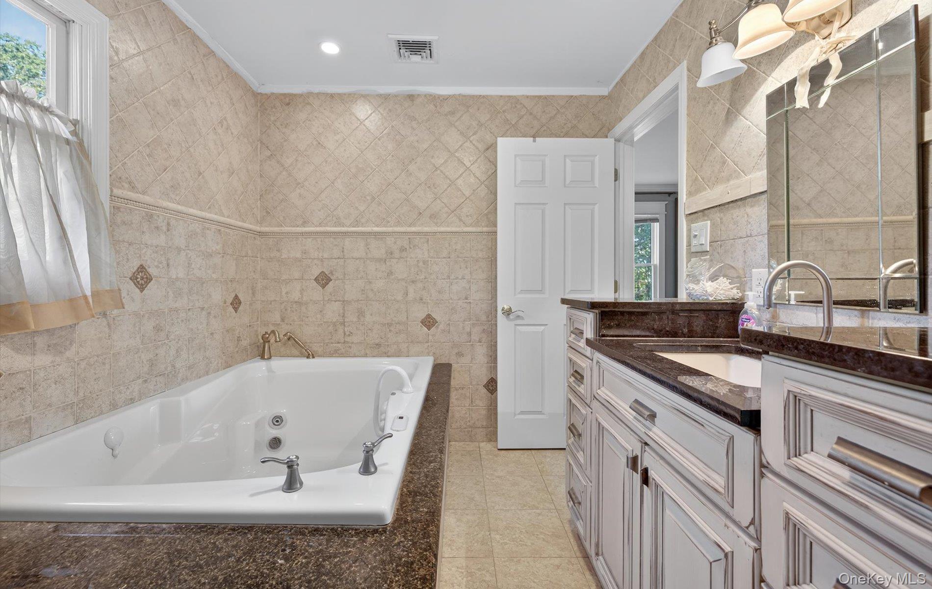 171 Dix Hills Road Dix Hills, NY 11746 - Photo 24 of 39 a bathroom with a granite countertop sink a toilet and bathtub