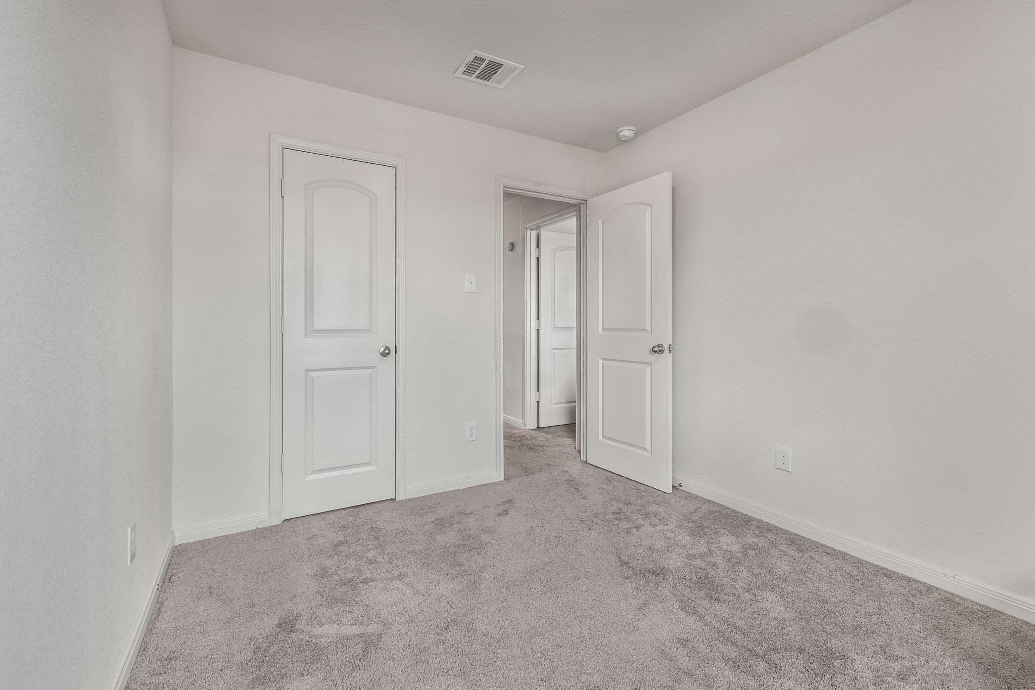 304 Hyacinth Way, Unit #7K Jarrell, TX 76537 - Photo 23 of 26 A well-maintained interior space with soft carpeting and functional doorways.