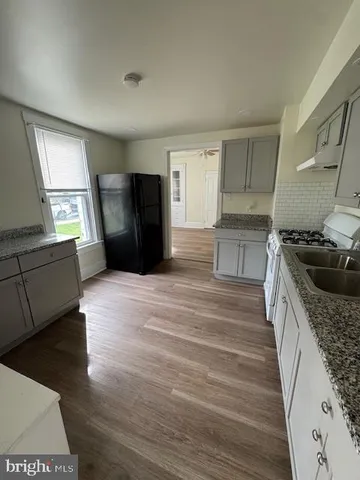 a kitchen with granite countertop a refrigerator and a sink