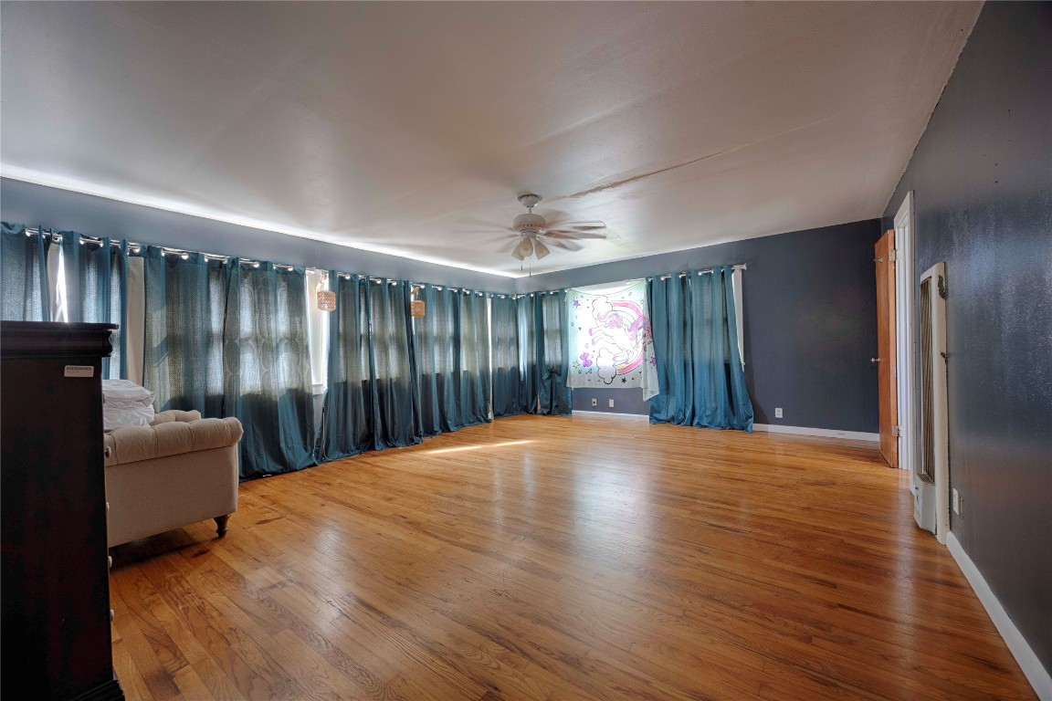 309 Anderson Street Schulenburg, TX 78956 - Photo 17 of 19 a view of an empty room with wooden floor and a window