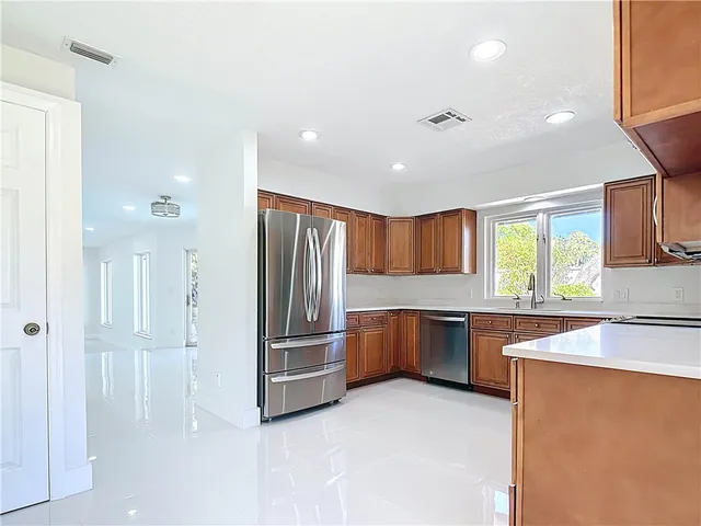 a kitchen with stainless steel appliances granite countertop a refrigerator and a sink