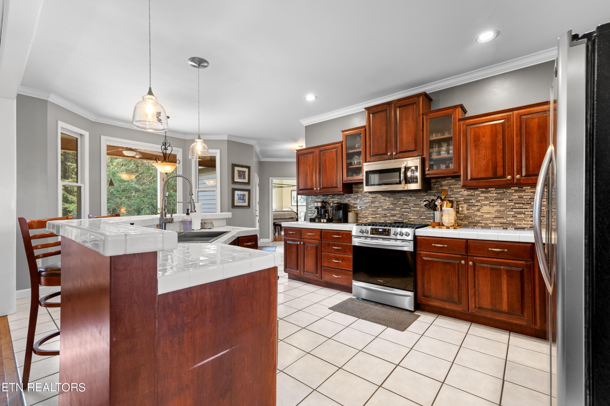 1443 West Dumplin Valley Road Dandridge, TN 37725 - Photo 22 of 51 a kitchen with stainless steel appliances granite countertop a stove top oven a sink dishwasher a dining table and chairs with wooden floor