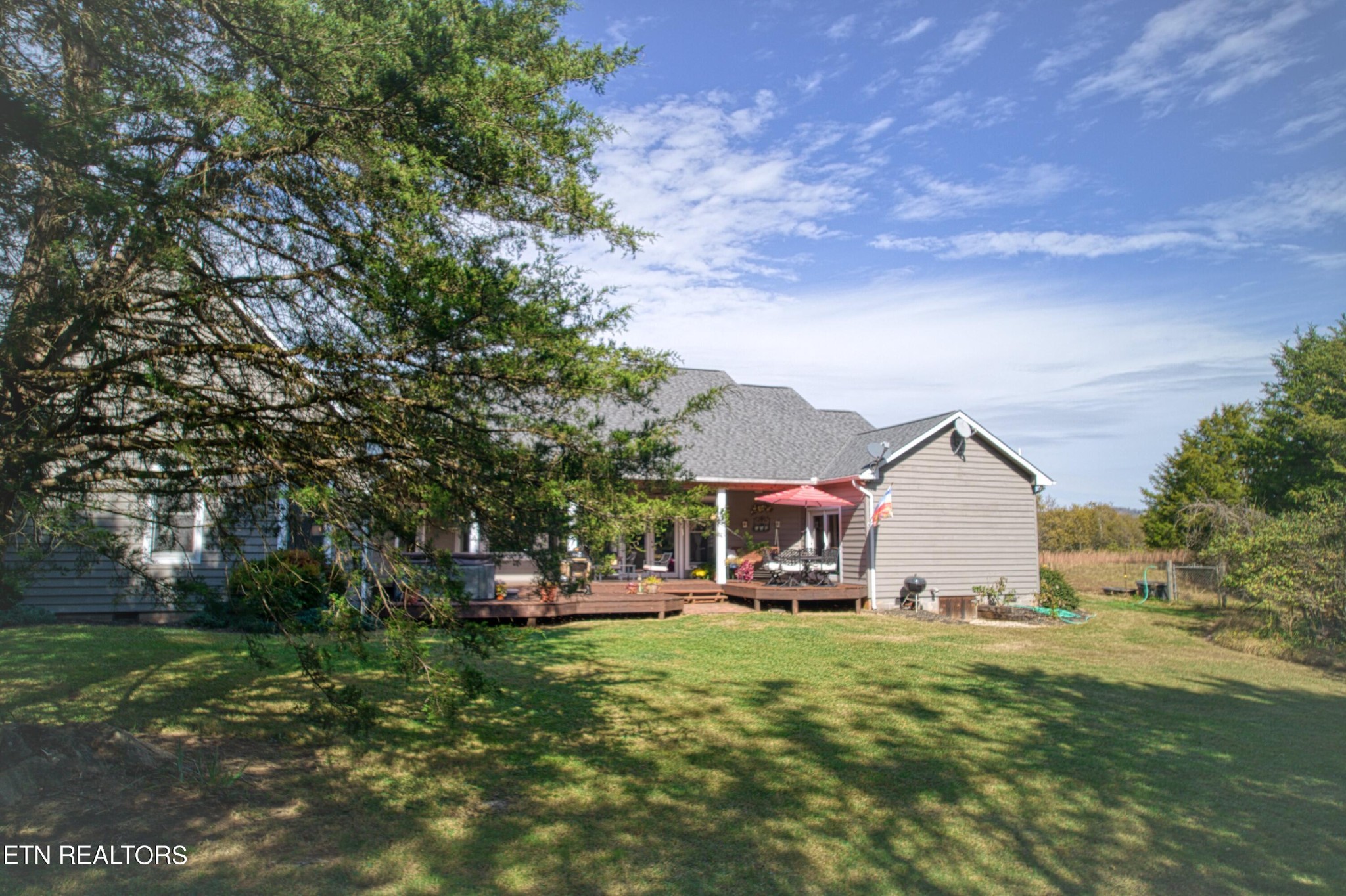 1443 West Dumplin Valley Road Dandridge, TN 37725 - Photo 45 of 51 a view of a house with a big yard potted plants and large tree
