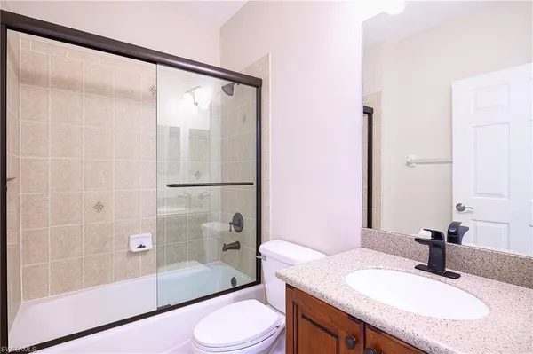 a bathroom with a granite countertop sink toilet and shower