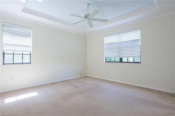 an empty room with a window and a ceiling fan