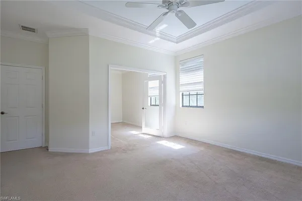 an empty room with a ceiling fan and windows