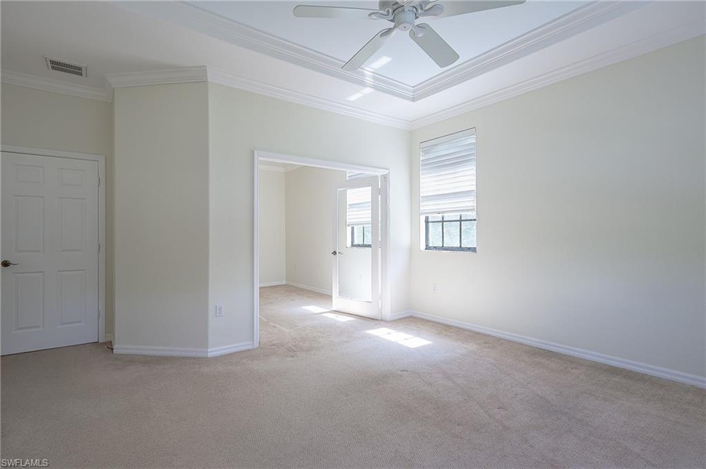 15056 Summit Pl Circle, Unit 228 Naples, FL 34119 - Photo 16 of 27 an empty room with a ceiling fan and windows
