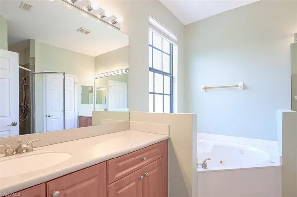 a bathroom with a tub sink and mirror