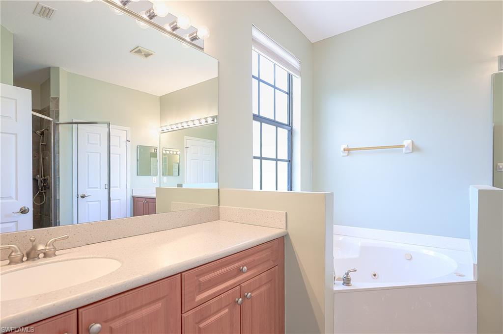 15056 Summit Pl Circle, Unit 228 Naples, FL 34119 - Photo 18 of 27 a bathroom with a tub sink and mirror