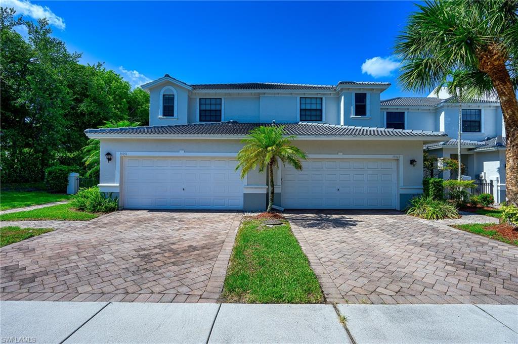 15056 Summit Pl Circle, Unit 228 Naples, FL 34119 - Photo 2 of 27 a front view of a house with a yard and garage