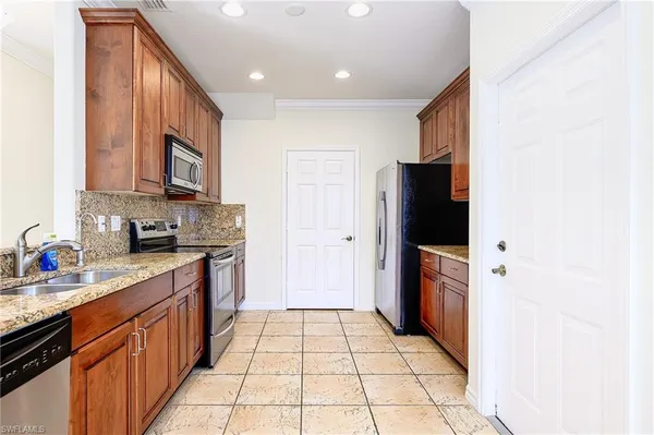 a kitchen with stainless steel appliances granite countertop a refrigerator and a stove top oven