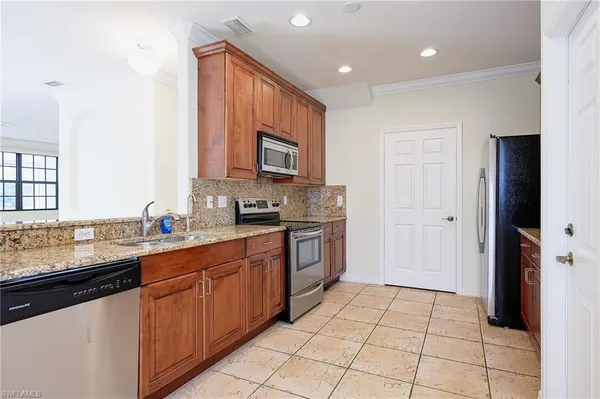 a kitchen with stainless steel appliances granite countertop a sink and cabinets