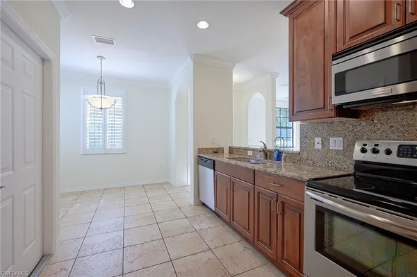 a kitchen with stainless steel appliances granite countertop a stove a sink and a microwave