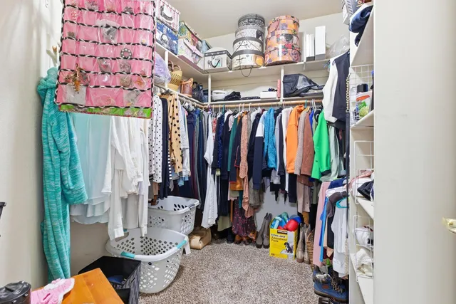 a view of walk in closet with clothes