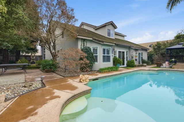 a view of a house with swimming pool and sitting area