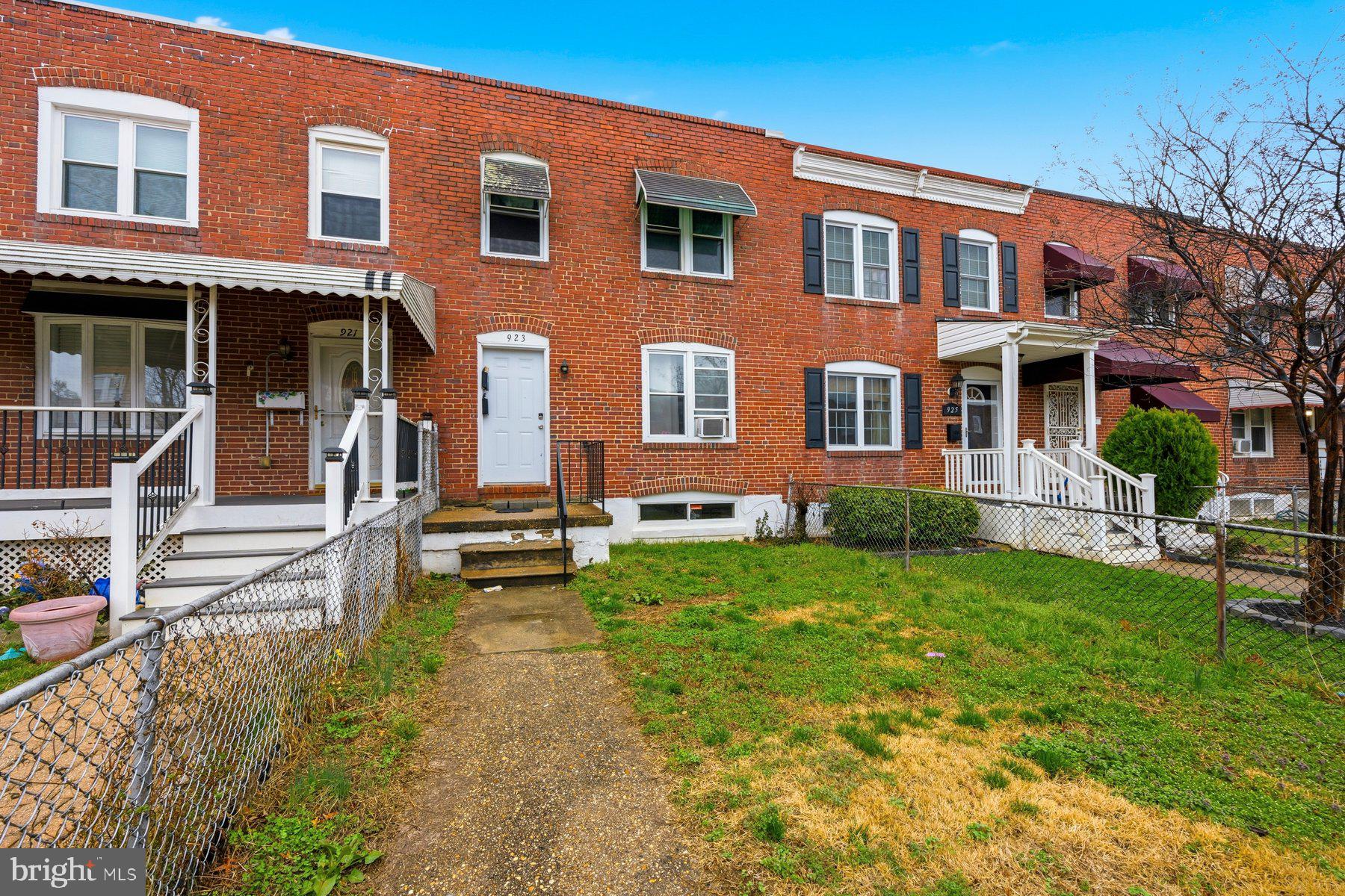 923 1st Street Baltimore, MD 21225 - Photo 2 of 32 front view of a brick house with a yard