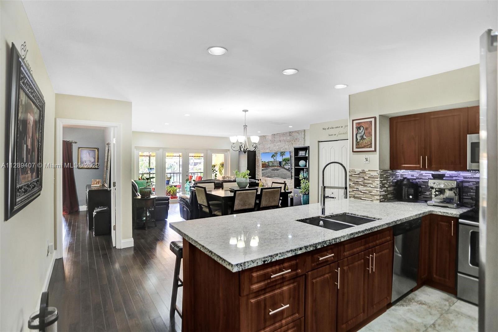 16511 Bridge End Road Miami Lakes, FL 33014 - Photo 16 of 43 a kitchen with a sink a counter and chairs