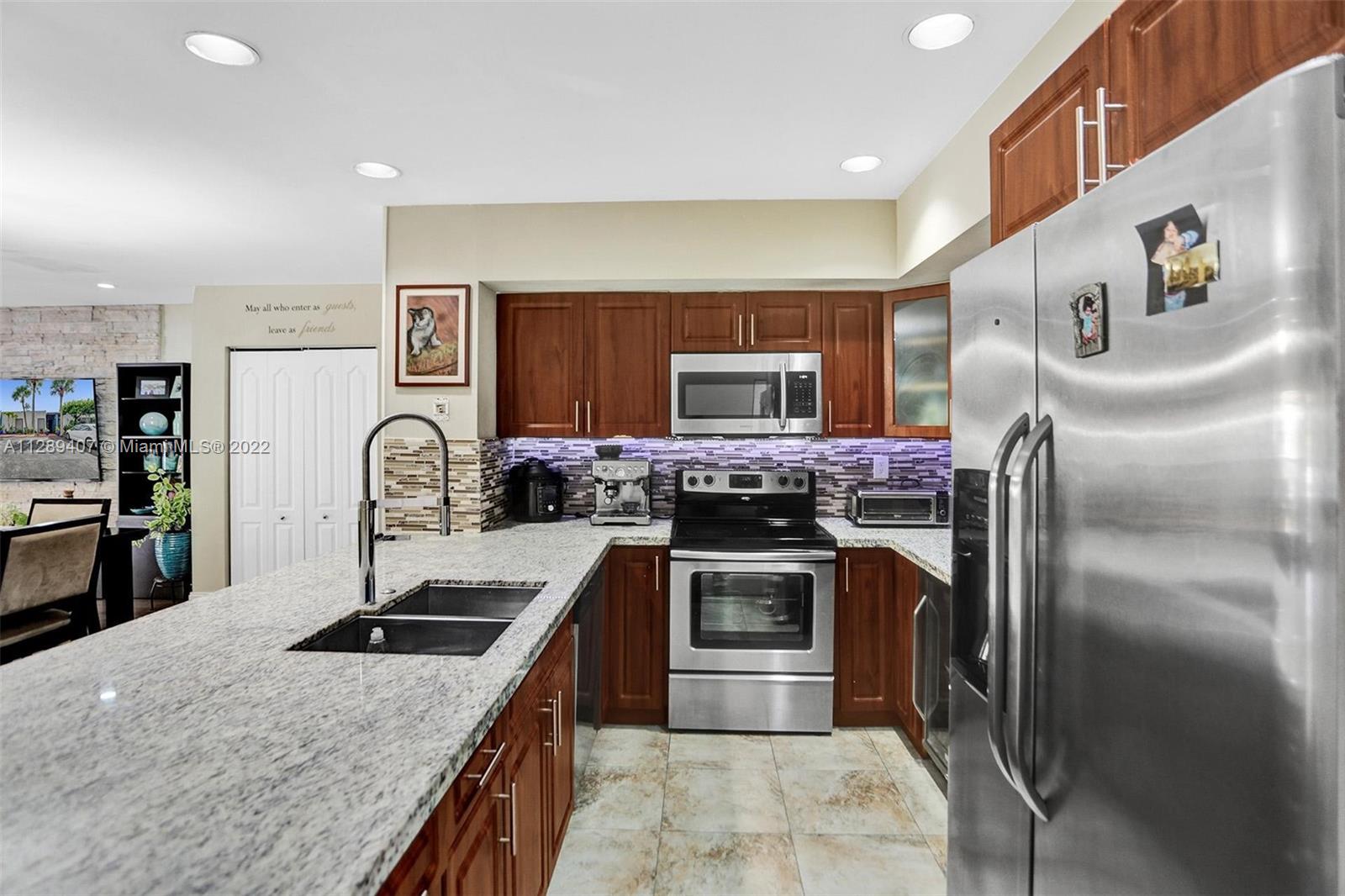 16511 Bridge End Road Miami Lakes, FL 33014 - Photo 18 of 43 a kitchen with stainless steel appliances granite countertop a sink and a refrigerator