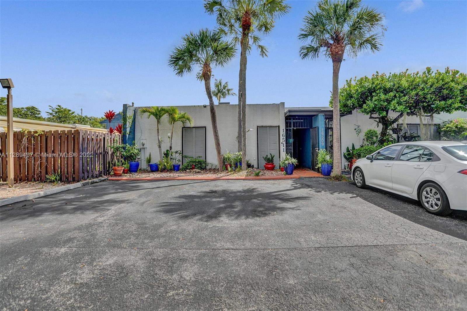16511 Bridge End Road Miami Lakes, FL 33014 - Photo 3 of 43 a view of a house with a yard and palm trees