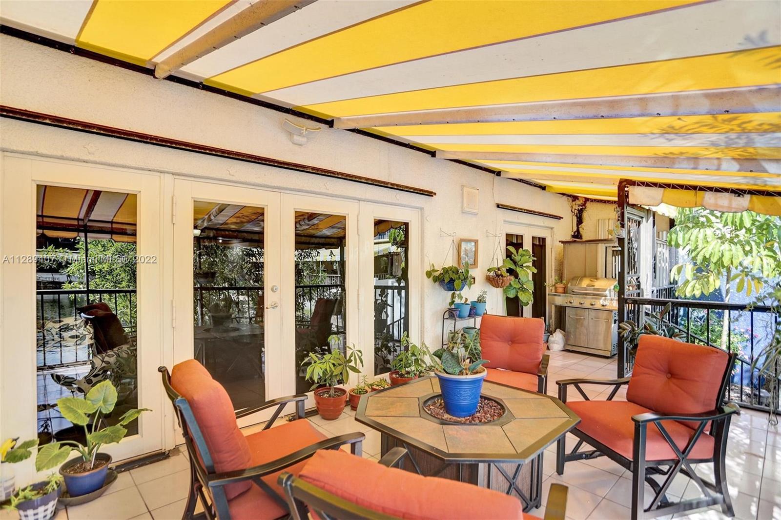 16511 Bridge End Road Miami Lakes, FL 33014 - Photo 37 of 43 a view of a patio with a dining table and chairs next to a yard